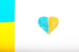 Flag of Ukraine on a white background and paper heart, painted in the color of the flag of Ukraine. The symbol of state photo
