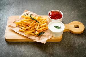 papas fritas con crema agria y salsa de tomate foto