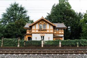 Beautiful old authentic Swiss house next to railroad tracks photo