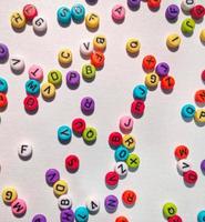 Colorful alphabet and number beads on white background photo