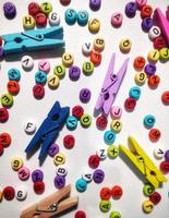 Colorful alphabet and number beads on white background photo