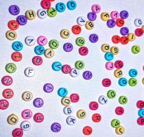 Colorful alphabet and number beads on white background photo