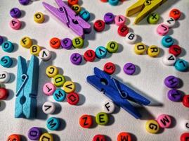 Colorful alphabet and number beads on white background photo