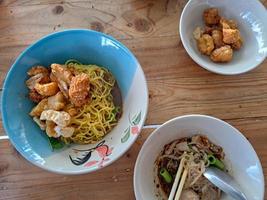 comida callejera en tailandia, fideos espolvoreados con piel de cerdo frita foto