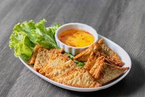 Triangular fried tofu eating with spicy dipping sauce, sweet and spicy photo