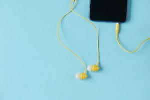 smart phone and headphone on wooden background . photo