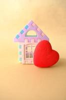 a house and heart shape symbol on color background photo