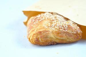 fresh bagel bread in a paper on table photo