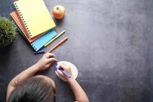 top view of child girl drawing on table photo