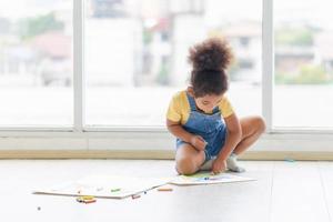 Cheerful kid draw a picture in creativity in living room, Child girl drawing on floor indoors photo