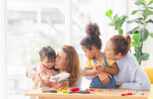 Adorable little child mould from plasticine with mother and grandmother, Grandmother and grandchildren playing cheerfully in living room photo