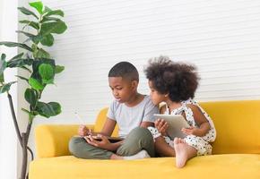 Children girl looking kid boy with graphite pencil drawing picture at home, Kids brother and sister playing together in living room photo