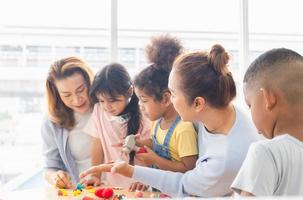 abuelas y niños jugando juguetes y juegos en la sala de estar, abuela pasando tiempo feliz con niños pequeños y niñas foto