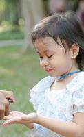 la mano de la niña estaba empapada con un spray de alcohol, rociado por su padre. prevenir la propagación de gérmenes y bacterias y evitar infecciones por coronavirus. concepto de higiene infantil foto