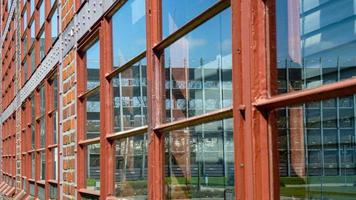 Closeup of the windows of a brick building reflecting the city photo