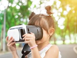 al aire libre parque verde jardín público niña niño bebé mujer hembra vestir rojo simulador auriculares realidad virtual tecnología digital vídeo cibernético red medios información datos análisis entretenimiento pantalla foto