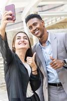 gente de negocios que usa un teléfono inteligente para selfie. gente de negocios de diversidad interracial feliz con smartphone tomando selfie o videollamada. gente de negocios exitosa tomando un selfie feliz foto