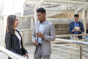 Group of business people.Business people meeting talking and sharing their ideas in city. Business team and teamwork concept. Business people standing outside in the city discussing about new project. photo