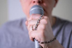 A man speaks into a microphone in close-up. photo