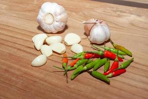 white garlic and Chili on wooden floor for cooking photo