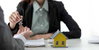 Close up hand of home,apartment agent or realtor was holding the key to the new landlord,tenant or rental.After the banker has approved and signed the purchase agreement successfully.Property concept. photo