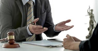 Business woman and lawyers discussing contract papers with brass scale on wooden desk in office. Law, legal services, advice, Justice concept. photo