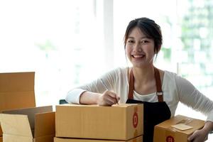 Portrait of Starting small businesses SME owners female entrepreneurs working on receipt box and check online orders to prepare to pack the boxes, sell to customers, sme business ideas online. photo