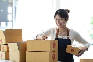 Portrait of Starting small businesses SME owners female entrepreneurs working on receipt box and check online orders to prepare to pack the boxes, sell to customers, sme business ideas online. photo