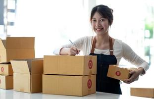 Portrait of Starting small businesses SME owners female entrepreneurs working on receipt box and check online orders to prepare to pack the boxes, sell to customers, sme business ideas online. photo