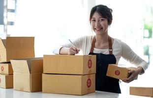 Portrait of Starting small businesses SME owners female entrepreneurs working on receipt box and check online orders to prepare to pack the boxes, sell to customers, sme business ideas online. photo