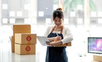 Portrait of Starting small businesses SME owners female entrepreneurs working on receipt box and check online orders to prepare to pack the boxes, sell to customers, sme business ideas online. photo
