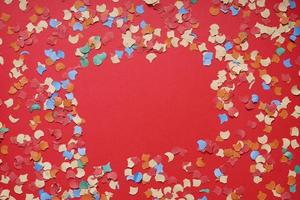 confetti frame on red paper background photo