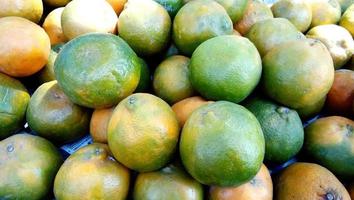 textura de naranjas frescas. manojo de naranjas frescas en el mercado, pila de naranjas. montón de naranjas frescas para el fondo. fondo de fruta naranja foto