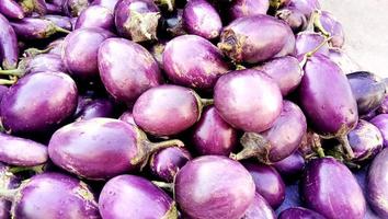 Close-up round fresh organic raw purple eggplant in farmer's market. Healthy and delicious purple eggplants background. photo