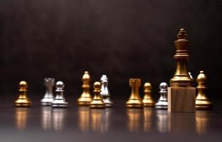 Golden king chess standing on a wooden stand. The concept of Leaders in good organizations must have a vision and can predict business trends and assess competitors photo