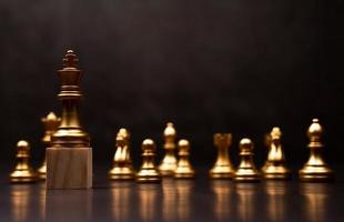ajedrez rey dorado de pie sobre un soporte de madera. el concepto de líderes en buenas organizaciones debe tener una visión y puede predecir las tendencias comerciales y evaluar a los competidores foto