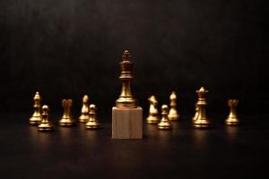 Golden king chess standing on a wooden stand. The concept of Leaders in good organizations must have a vision and can predict business trends and assess competitors photo