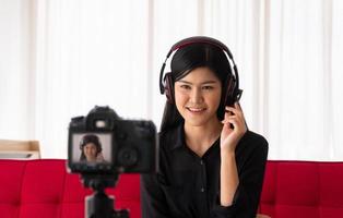 Vlog Asian woman blogger influencer sitting on the sofa in home and recording video blog for teaching and coach her Students or subscriber. Concept of the content creator online for a new lifestyle photo