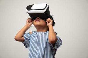 la pequeña niña asiática con casco de realidad virtual es emocionante para nuevas experiencias. concepto de tecnología de gadgets 3d y juegos de gadgets del mundo virtual y educación en línea en el futuro foto
