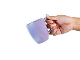 The old purple coffee mug is tilted in his hand, asking for a cup of coffee or a hot drink. Ready to continue working and have clipping path on isolated background photo