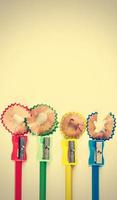 Colored pencils, sharpener and shavings on vintage style. Vertical image. photo