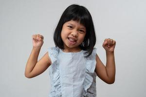 retrato de una niña asiática de 5 años y para recoger el pelo y una gran sonrisa en un fondo blanco aislado, ella es felicidad, resplandor en la juventud foto