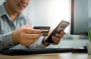 A Man holding credit card and using smartphone for payment online for purchase after order products via the internet. The concept of technology for e-commerce electronic commerce