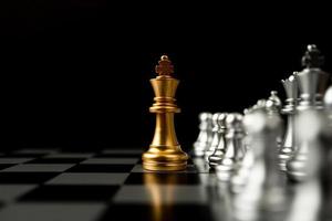 Golden King chess standing in front of other chess, Concept of a leader must have courage and challenge in the competition, leadership and business vision for a win in business games photo