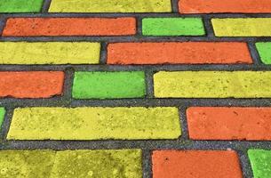 Beautiful rainbow colored bricks on an old and weathered wall texture photo