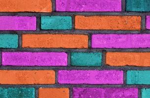 Beautiful rainbow colored bricks on an old and weathered wall texture photo