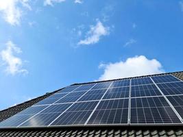 Solar panels producing clean energy on a roof of a residential house photo