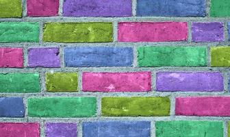 Beautiful rainbow colored bricks on an old and weathered wall texture