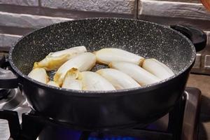 Chicory stew in pan on gas stove according to recipe from the Internet photo