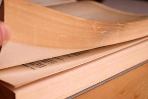 Selective focus view of an old thick german mathematics book with a male hand searching in it. photo